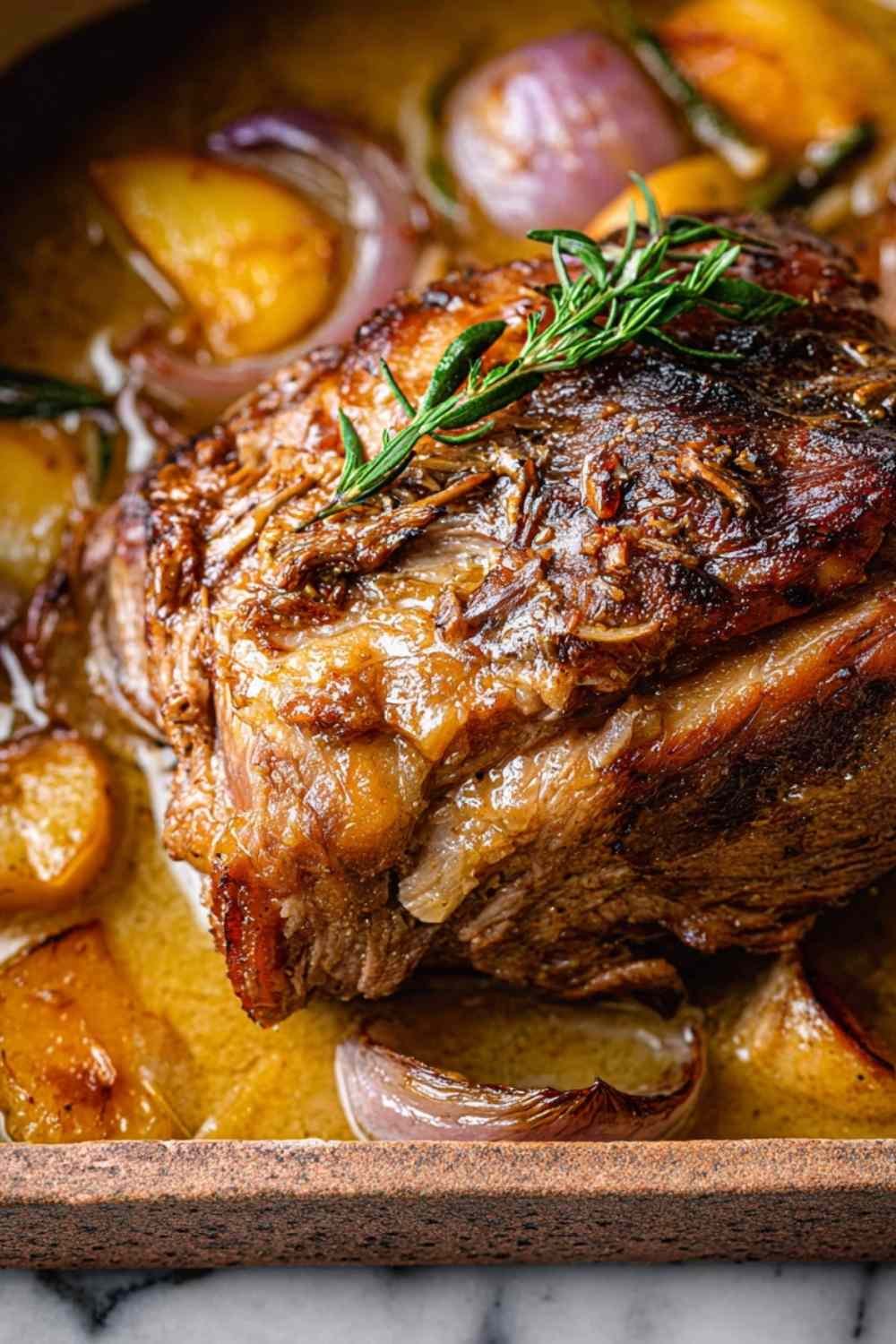 Finished Apple Cider Braised Beef with apples and onions in serving dish.