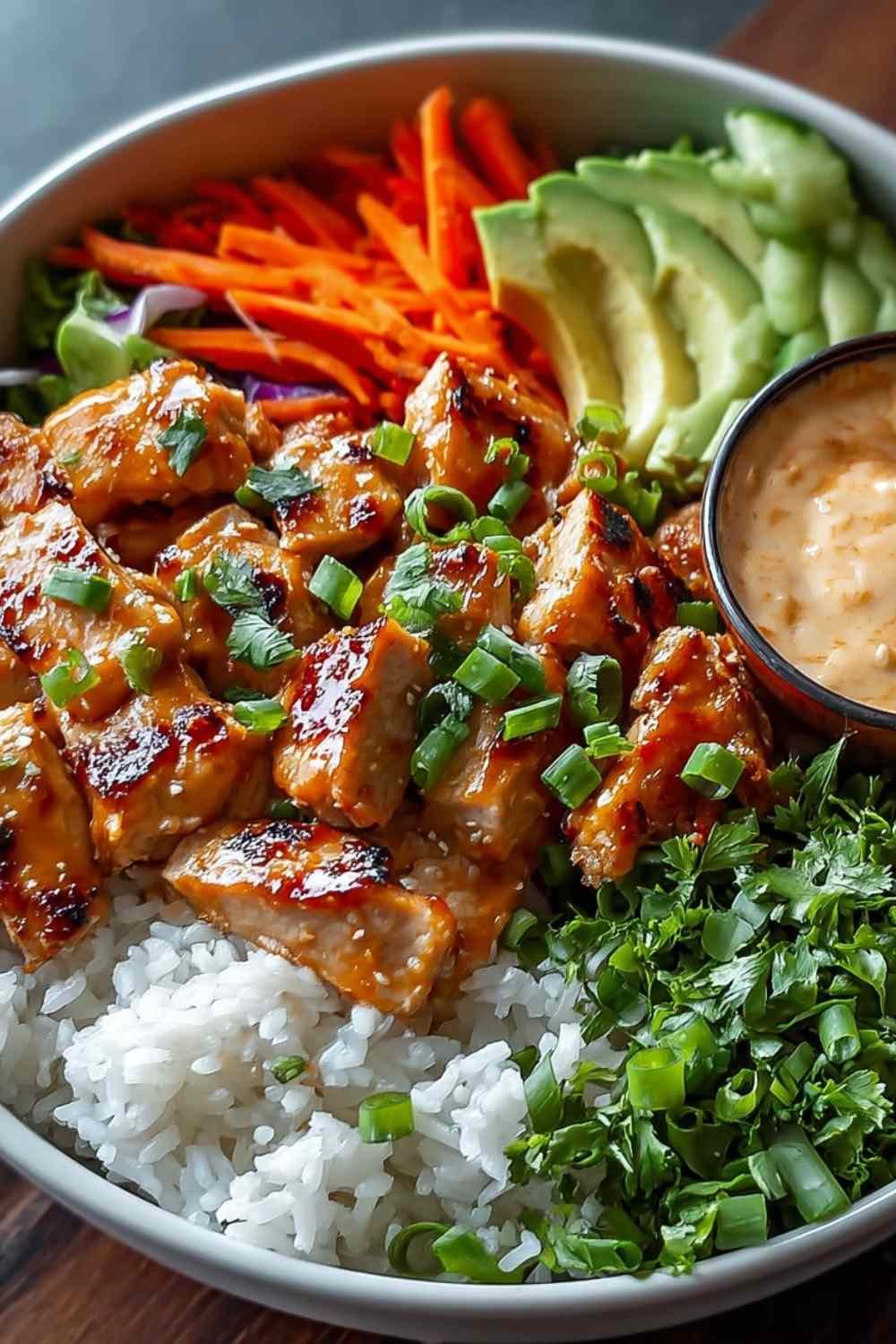 Bang Bang Chicken Bowl with tender chicken, colorful vegetables, and creamy spicy sauce over rice in a white bowl