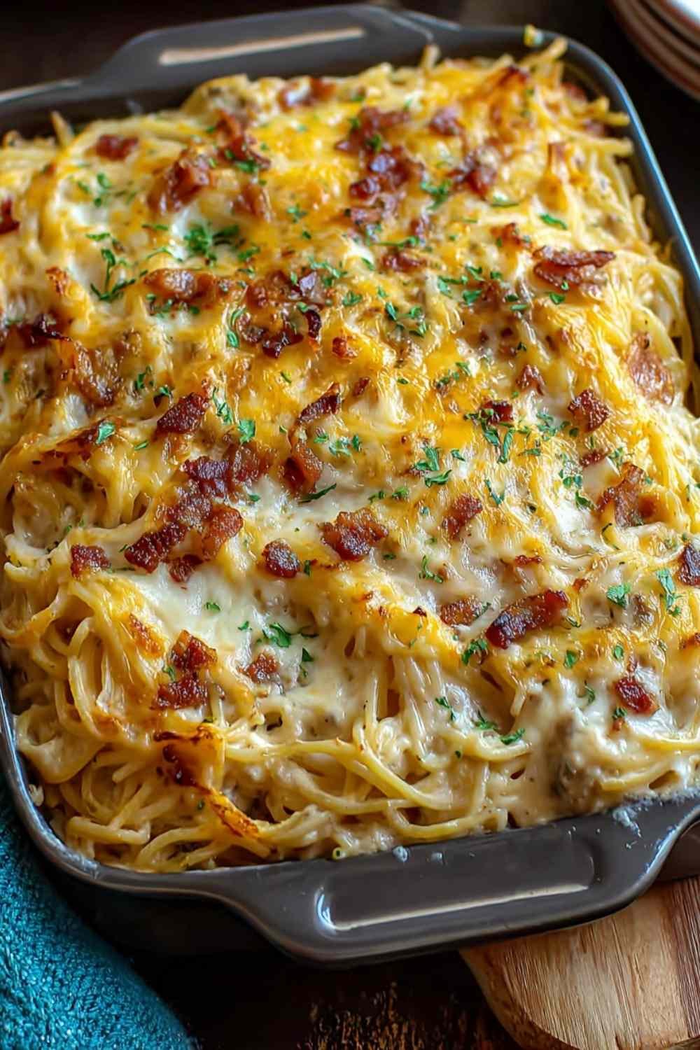 Creamy Southern Spaghetti Bake with melted cheese and bacon in white baking dish