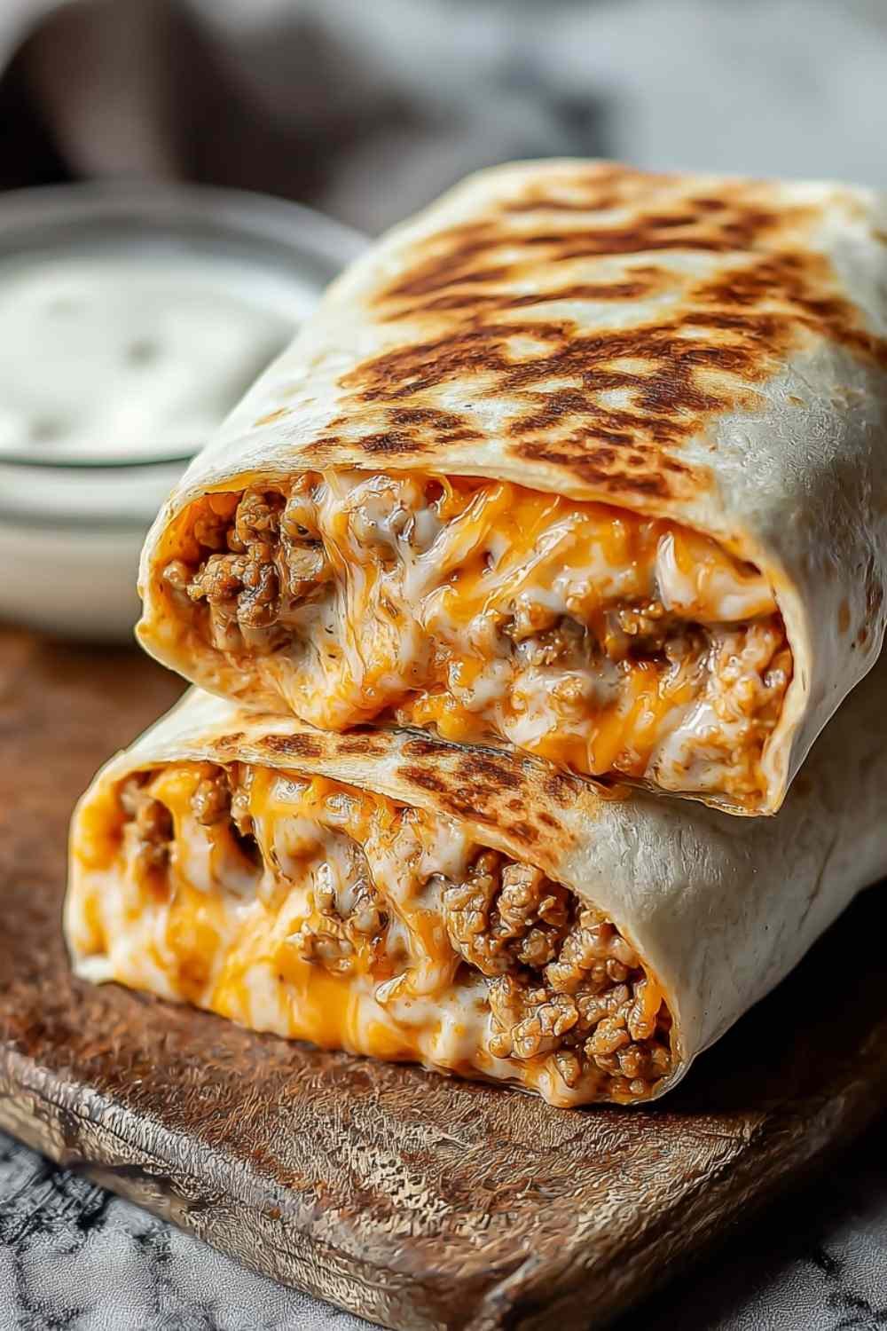 Homemade grilled cheese burrito with golden crispy cheese crust cut in half showing seasoned beef and rice filling