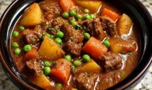Bowl of healthy crockpot beef stew with tender meat, carrots, and potatoes in rich gravy