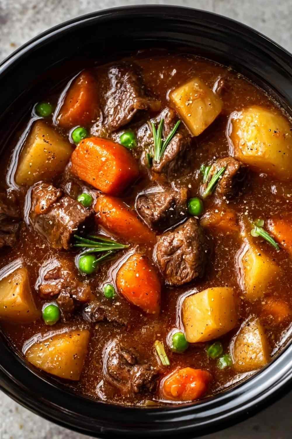 Bowl of healthy crockpot beef stew with tender meat, carrots, and potatoes in rich gravy