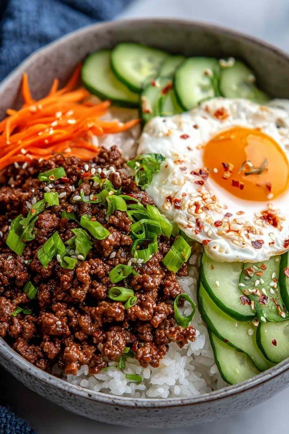 Korean Ground Beef Bowl served over white rice topped with green onions and sesame seeds in white bowl