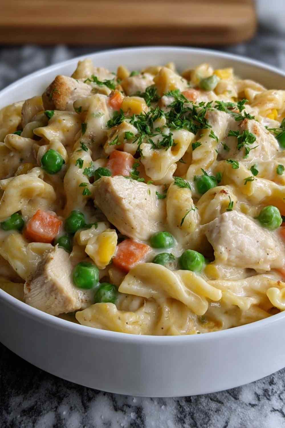 Quick chicken pot pie pasta in large skillet with creamy sauce coating egg noodles and vegetables