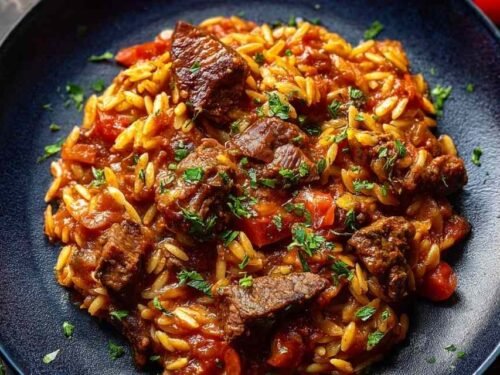 Beef Giouvetsi recipe with tender beef and orzo pasta in rich tomato sauce served in Dutch oven