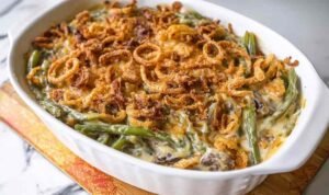 Green bean casserole mixture in casserole dish ready to bake with creamy sauce