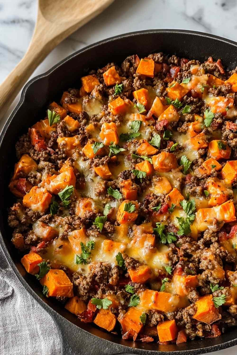 Ground beef sweet potato skillet with melted cheese, poblano peppers and corn in large nonstick pan