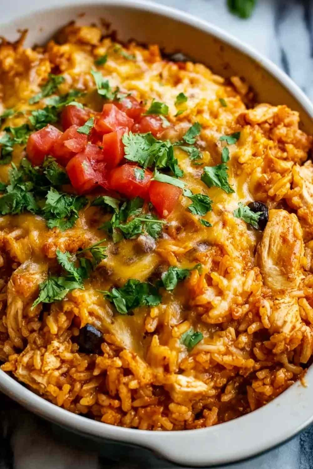 Chicken Enchilada Rice Casserole in baking dish topped with melted cheese and fresh cilantro