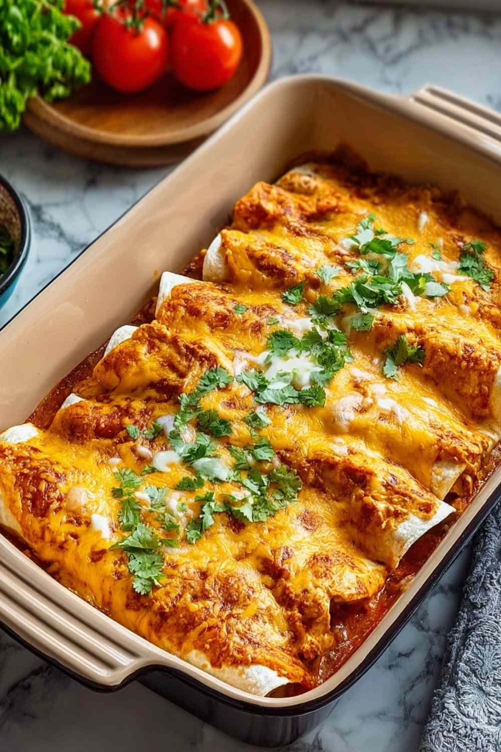 High protein creamy chilli chicken enchiladas topped with melted cheese, sour cream, and cilantro on white plate