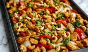 Sheet Pan Cashew Chicken with bell peppers and cashews on white serving platter