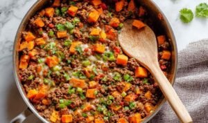 Southwest ground beef and sweet potato skillet with melted cheese and fresh cilantro in large skillet ready to serve