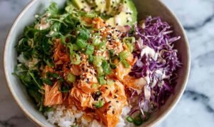 Spicy salmon bowl with glazed salmon pieces over Asian cabbage slaw drizzled with sriracha mayo