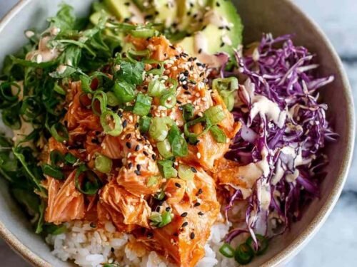 Spicy salmon bowl with glazed salmon pieces over Asian cabbage slaw drizzled with sriracha mayo