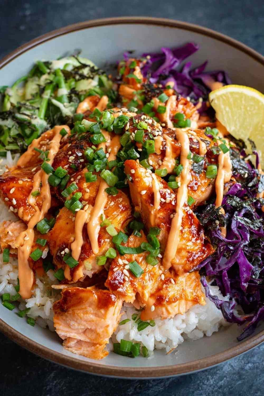 Spicy salmon bowl with glazed salmon pieces over Asian cabbage slaw drizzled with sriracha mayo