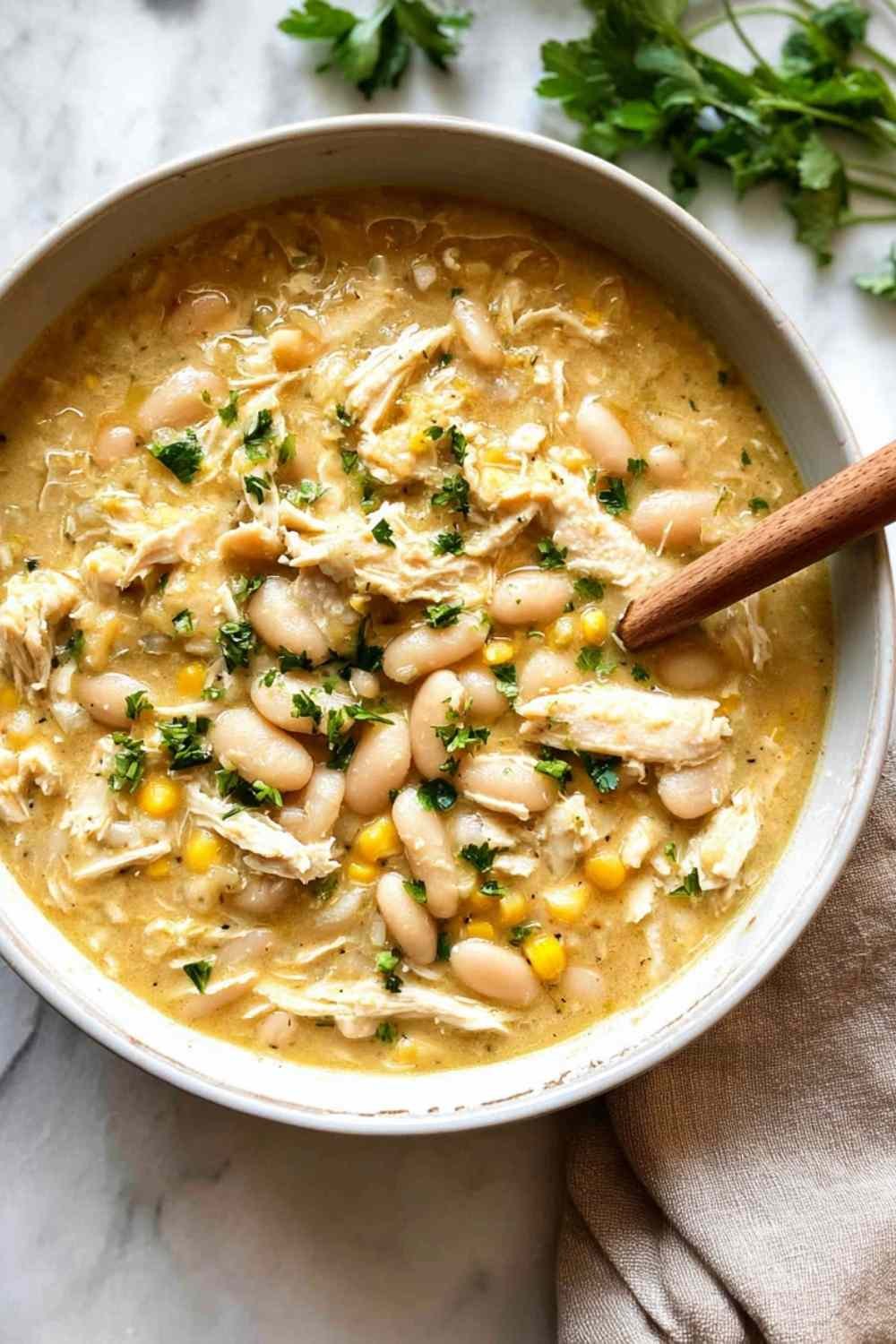 Creamy white chicken chili with beans and corn in a large pot ready to serve