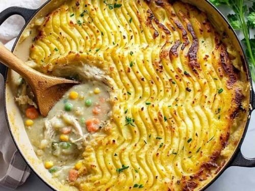 Chicken shepherd's pie with golden mashed potato topping in white serving bowl