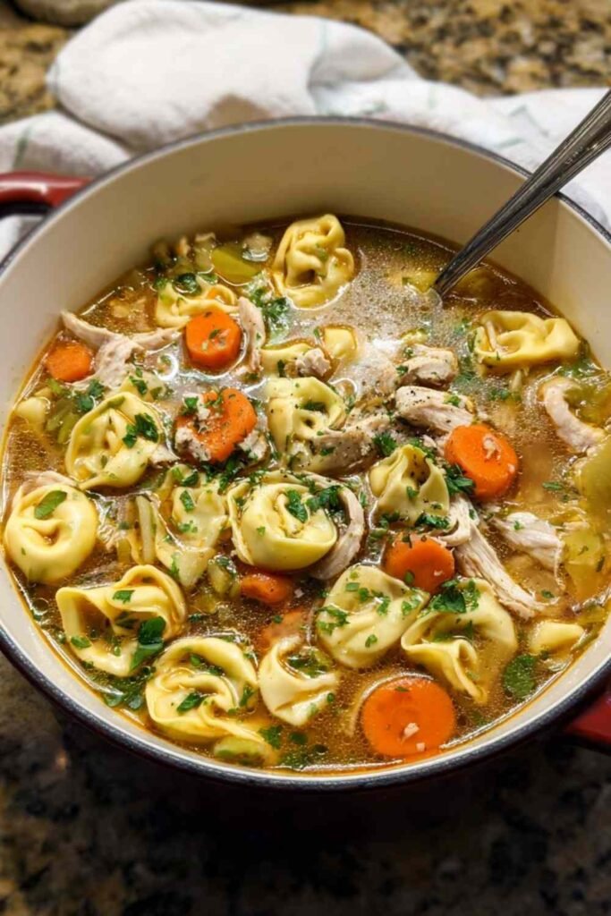 Hearty Chicken Tortellini Soup with vegetables and cheese tortellini in a white bowl