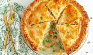Easy chicken pot pie slice with creamy filling and golden flaky crust on white plate