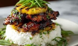 Hawaiian Huli Huli Chicken Stack with grilled chicken teriyaki pineapple and rice on white plate