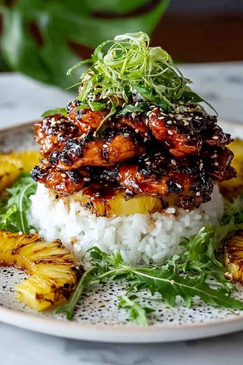 Hawaiian Huli Huli Chicken Stack with grilled chicken teriyaki pineapple and rice on white plate