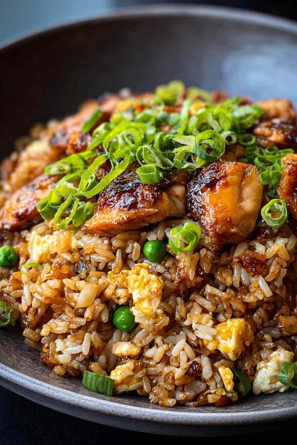 Japanese BBQ chicken fried rice cooking in large skillet with vegetables and green onions