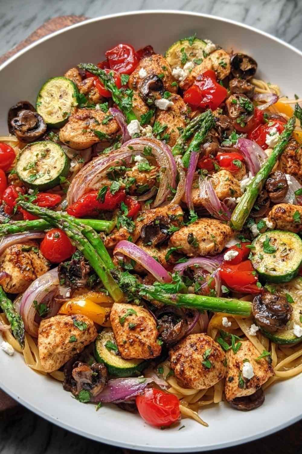 Mediterranean chicken stir fry in large skillet with zucchini tomatoes olives and herbs over barley