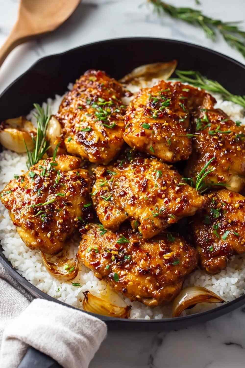 Honey garlic chicken pieces glazed with sticky sauce served over white rice garnished with parsley