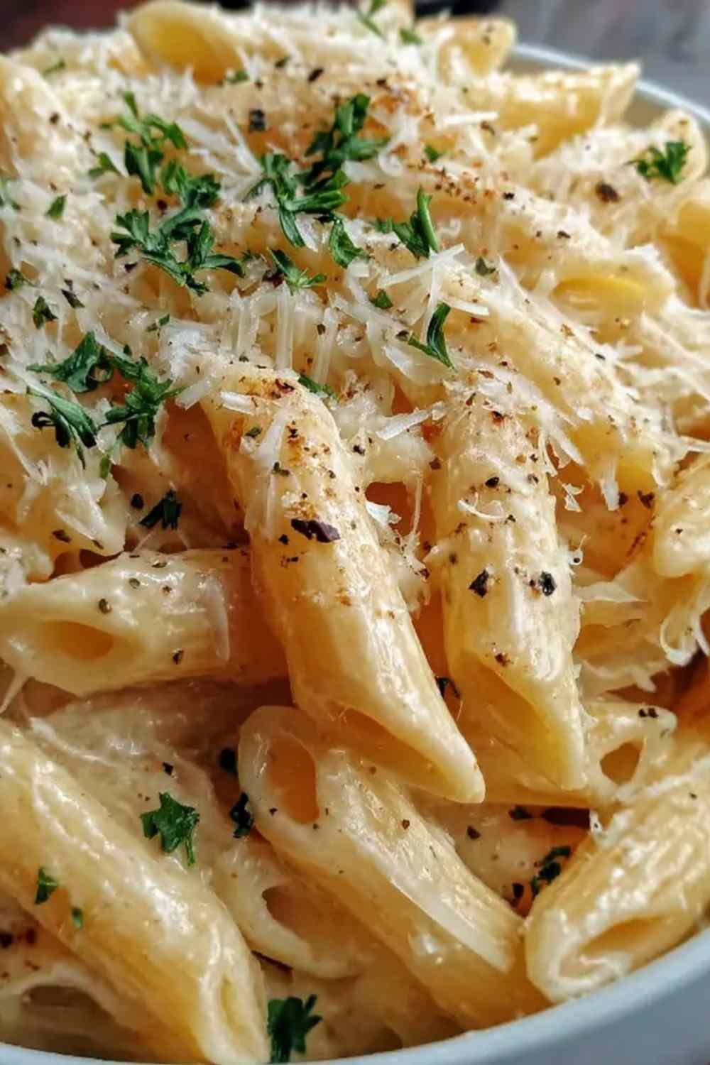 5 Ingredient Garlic Parmesan Pasta in a skillet with freshly grated Parmesan and minced garlic