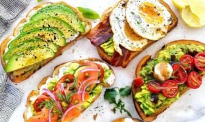Simple avocado toast on toasted sourdough bread drizzled with olive oil and topped with fresh parsley