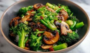 Broccoli and mushroom stir fry served over steamed white rice on a dinner plate