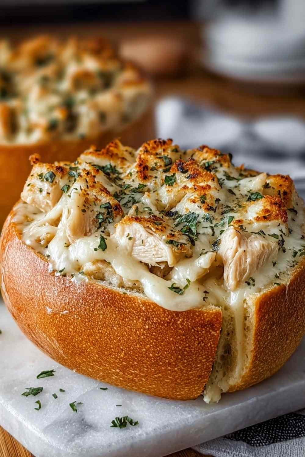 Chicken Alfredo garlic bread bowls filled with creamy pasta and chicken on serving plate