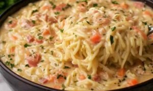 Crack chicken noodle soup in a white bowl with shredded chicken pasta noodles crumbled crispy bacon and melted cheddar cheese in a creamy ranch broth