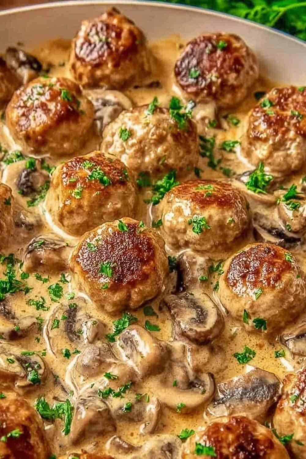Creamy mushroom chicken meatballs in a skillet with garlic mushroom cream sauce and fresh parsley