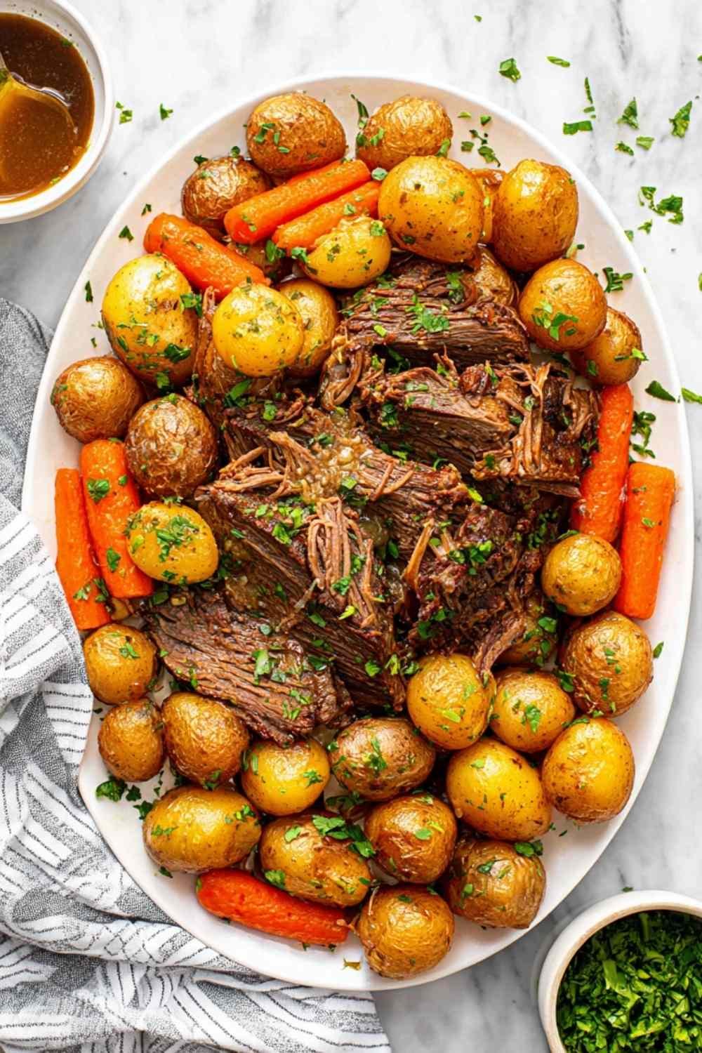 Tender crock pot pot roast with carrots, potatoes, and fresh herbs in a slow cooker, ready to serve
