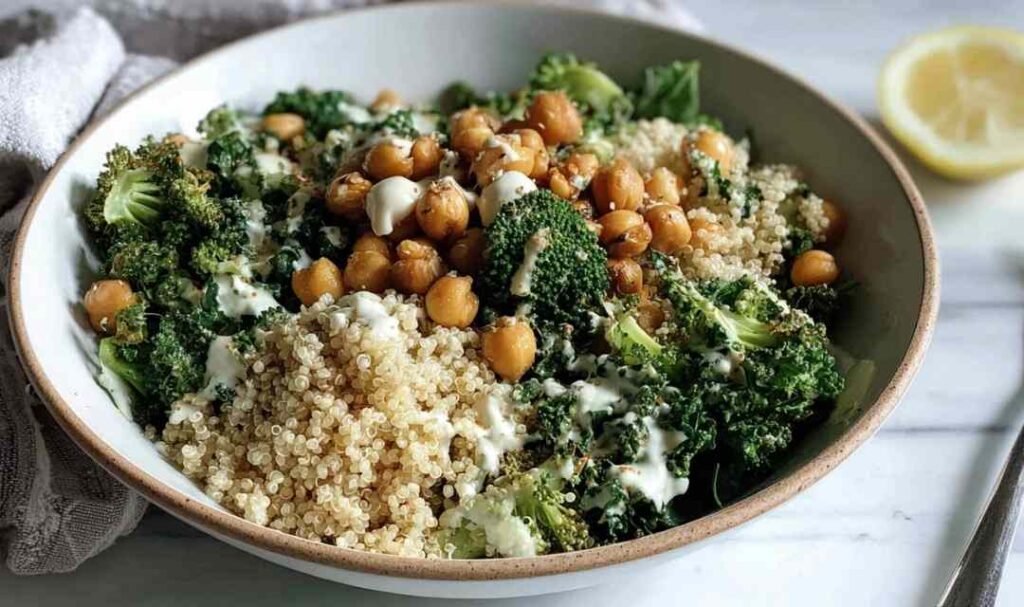 Kale Chickpea Quinoa Salad in a white bowl with crispy chickpeas roasted broccoli massaged kale fluffy quinoa and lemon tahini dressing
