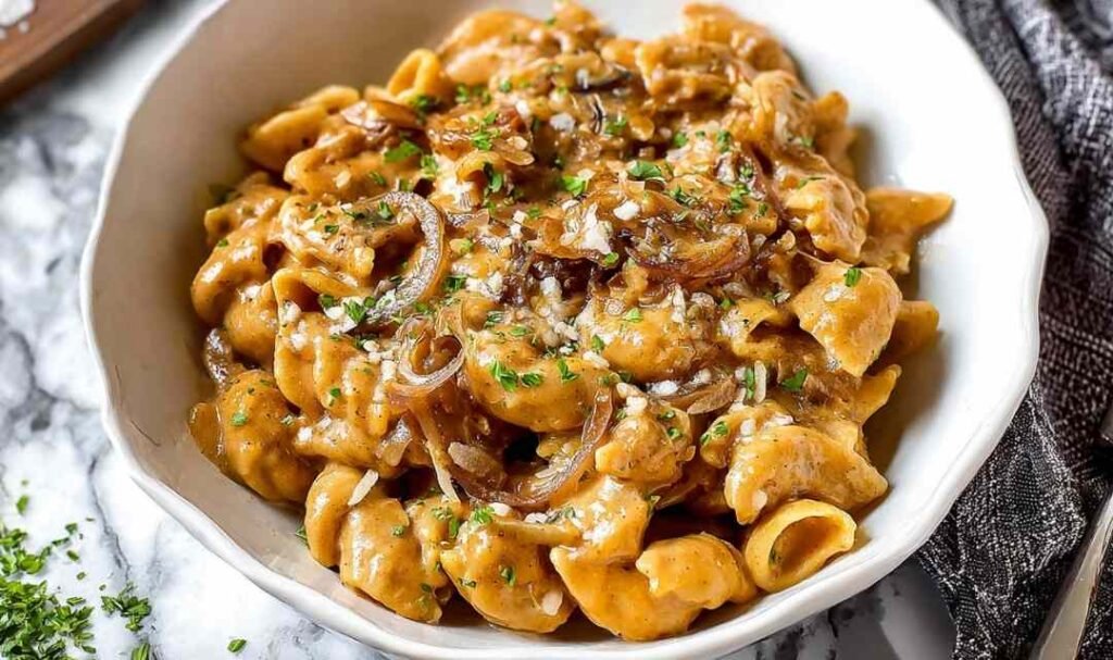 One pot French onion pasta with caramelized onions and melted Gruyere cheese served in white bowl for easy weeknight dinner