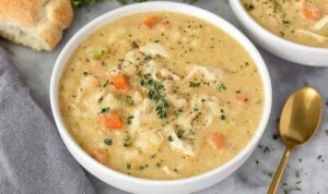 Bowl of creamy chicken pot pie soup garnished with fresh parsley showing tender chicken and vegetables