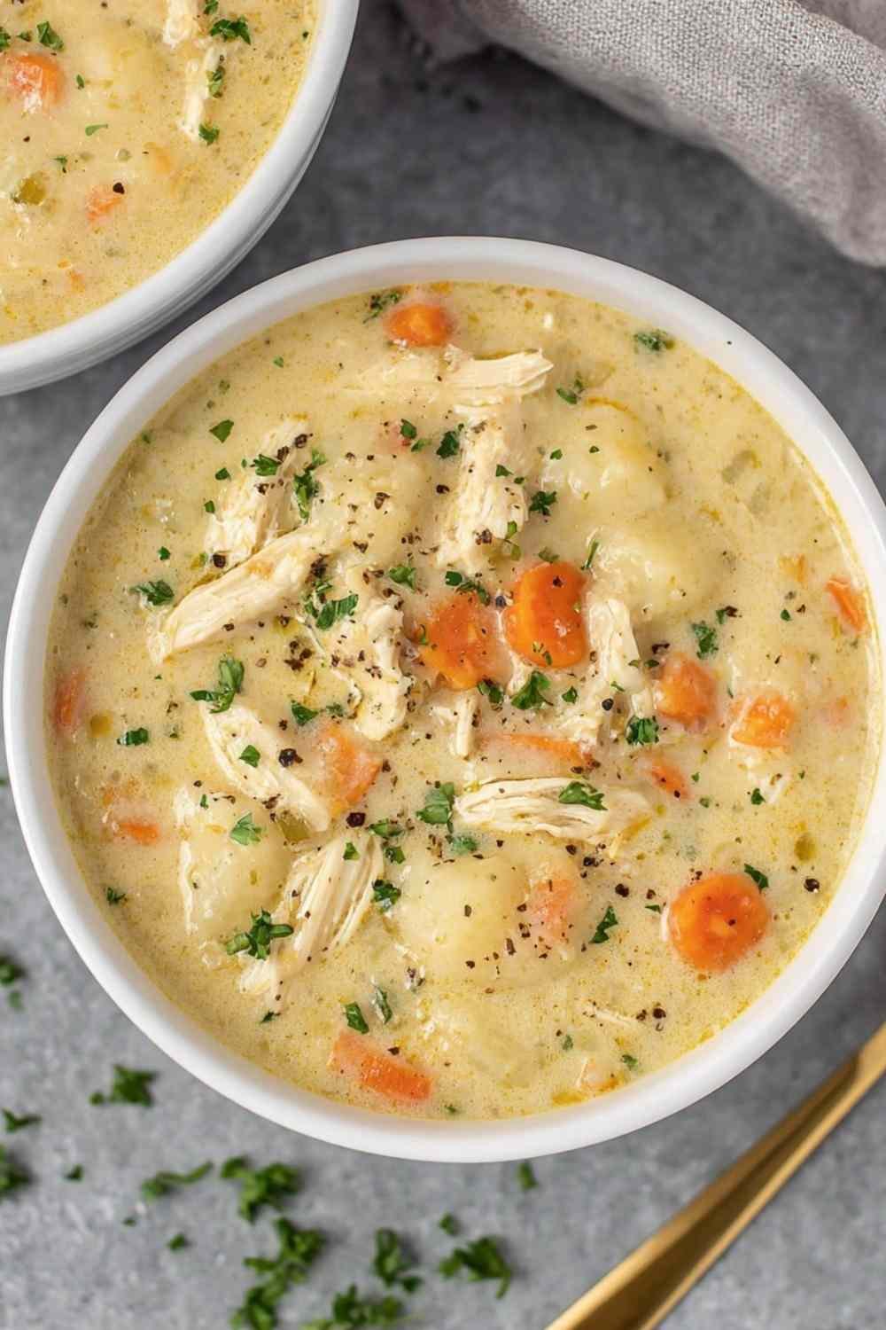 Bowl of creamy chicken pot pie soup garnished with fresh parsley showing tender chicken and vegetables