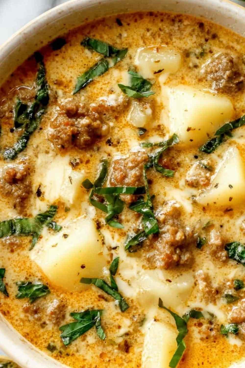 Creamy Italian sausage and potato soup in a bowl topped with Parmesan cheese and wilted kale