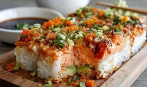 Spicy salmon sushi bake in baking dish with golden bubbly topping and green onion garnish