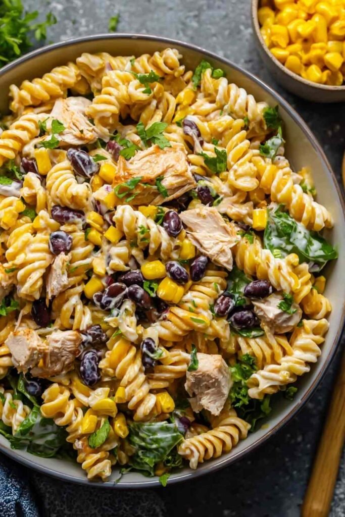 Overhead shot of BBQ Chicken Pasta Salad with shredded chicken, black beans, corn, and creamy BBQ dressing in a large white bowl