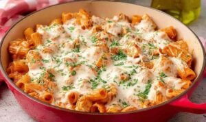 Baked chicken parmesan pasta in a 9x13 baking dish with golden broiled mozzarella and fresh basil