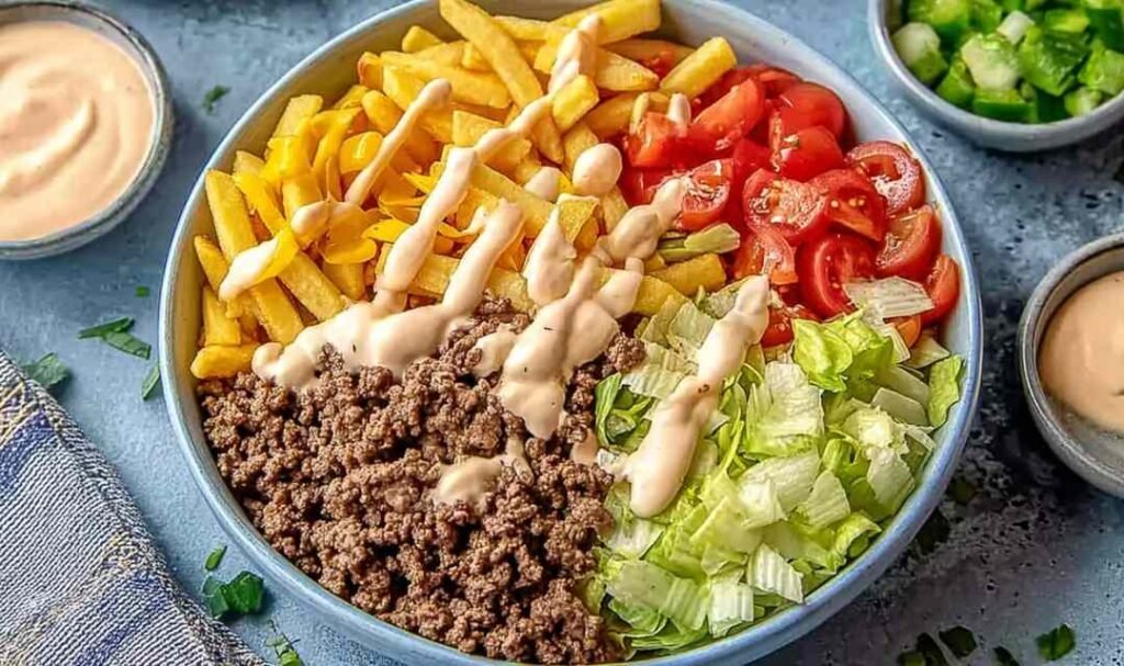 Homemade Big Mac Bowl with seasoned ground beef, shredded lettuce, cheddar cheese, and creamy special sauce in a white bowl