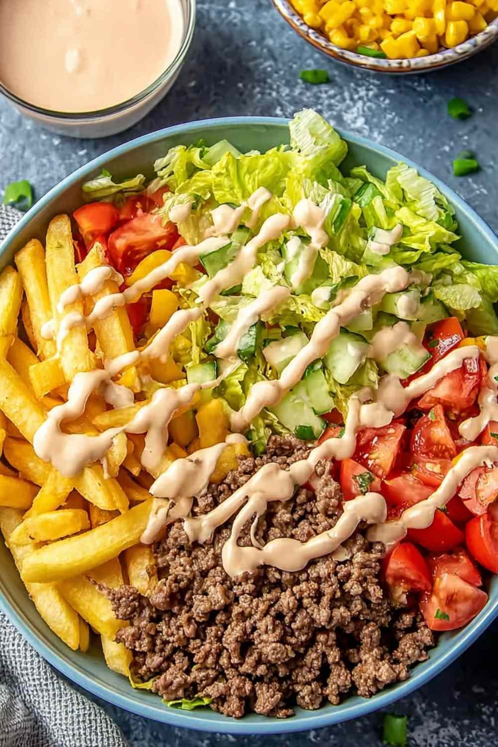 Homemade Big Mac Bowl with seasoned ground beef, shredded lettuce, cheddar cheese, and creamy special sauce in a white bowl