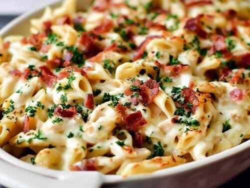 Chicken bacon ranch baked penne with golden melted mozzarella and crispy bacon in a white casserole dish
