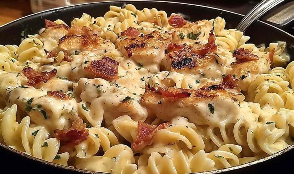 Chicken bacon ranch pasta in large skillet with creamy cheddar sauce rotini chopped bacon and cubed chicken