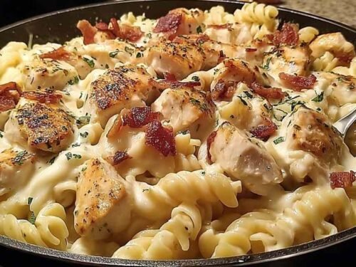Chicken bacon ranch pasta in large skillet with creamy cheddar sauce rotini chopped bacon and cubed chicken