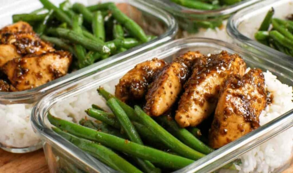 Chicken breast and green beans tossed in honey-soy sauce served over white rice in a bowl