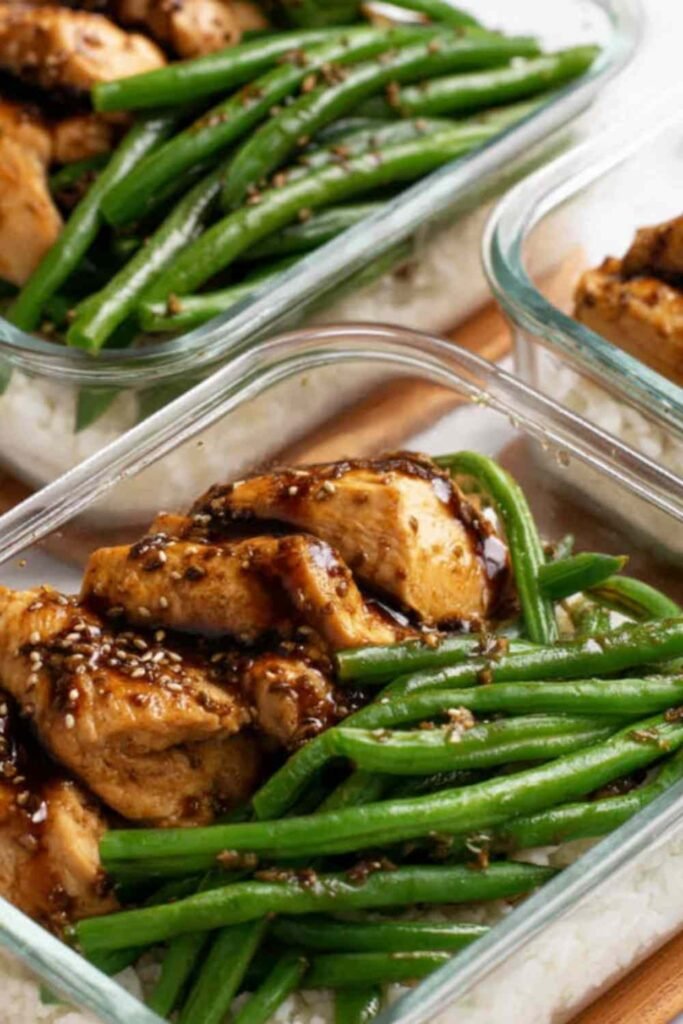 Chicken breast and green beans tossed in honey-soy sauce served over white rice in a bowl