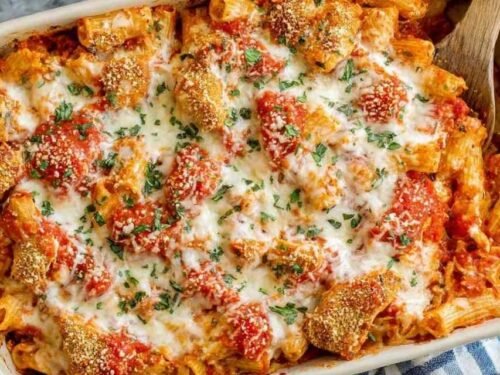 Chicken parmesan casserole with golden melted mozzarella and crispy breaded chicken in a white baking dish